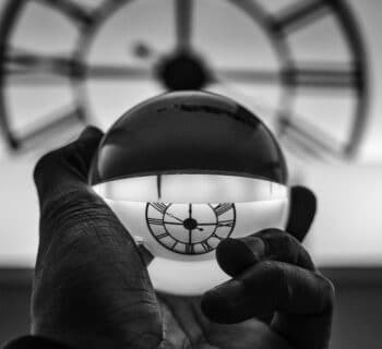 grayscale photography of person holding glass ball